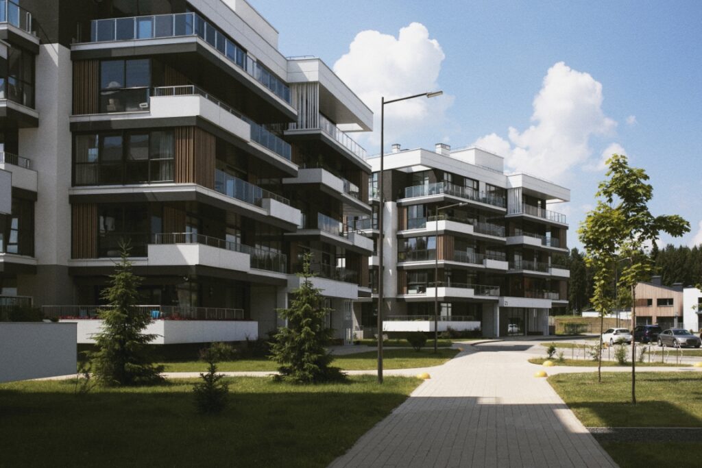 A Modern Residential Apartment Complex With Multiple Floors, Balconies, And Large Windows, Surrounded By Landscaped Greenery And Trees Under A Partly Cloudy Sky